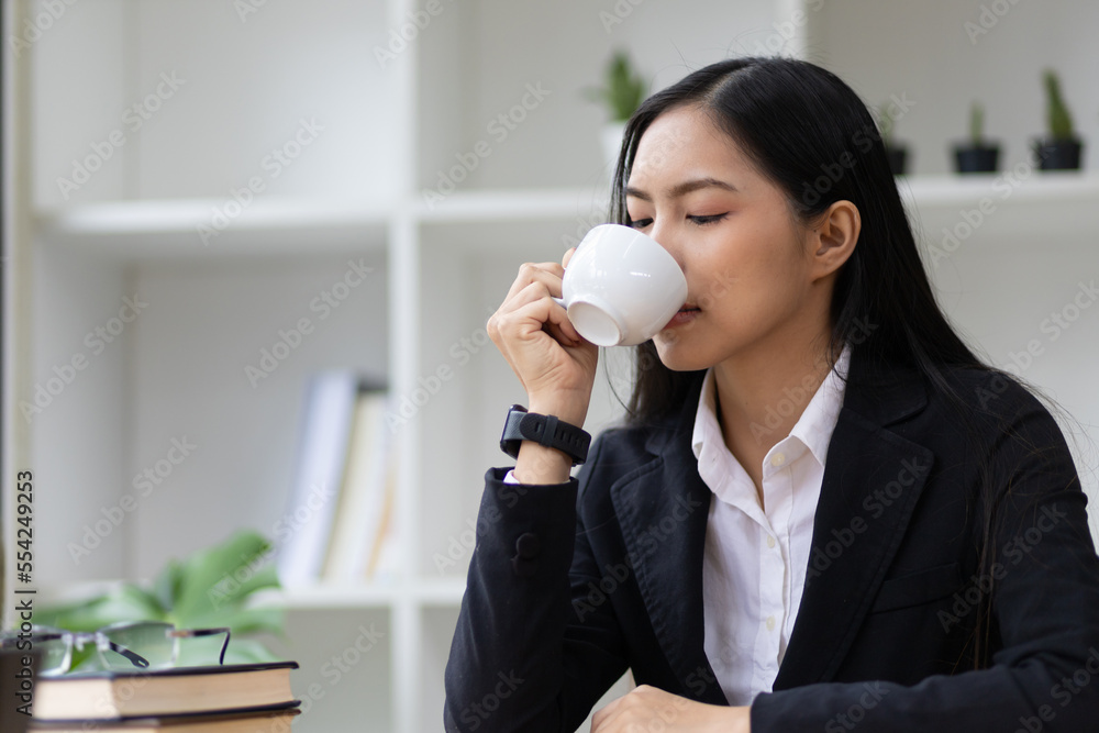 肖像女商人，一位有魅力的年轻亚洲女性，早上喝咖啡心情很好。