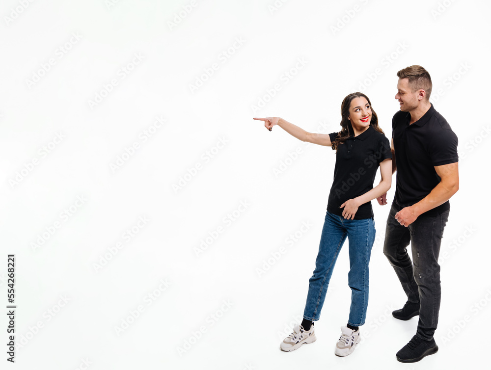 Young people in casual clothes looking away and point finger isolated on white background. Young cou