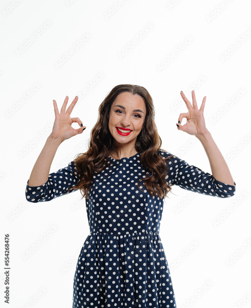 Funny and joyful girl shows okay sign looking at camera isolated on wight background. Relax all good