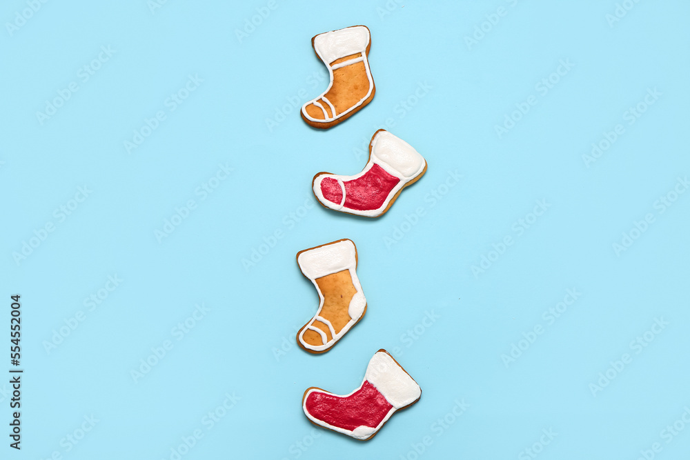 Tasty Christmas cookies in shape of socks on color background