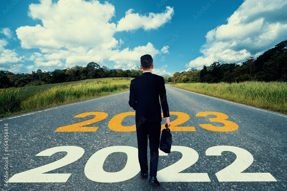 The 2023 New Year journey and future vision concept . Businessman traveling on highway road leading 