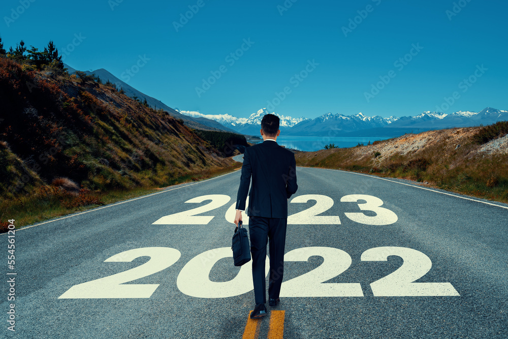 The 2023 New Year journey and future vision concept . Businessman traveling on highway road leading 