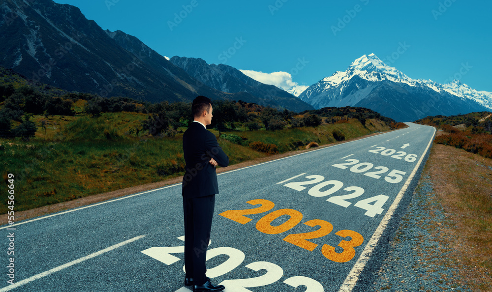 The 2023 New Year journey and future vision concept . Businessman traveling on highway road leading 