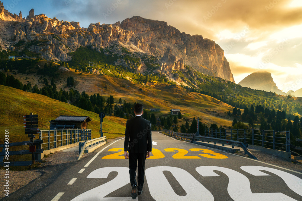 The 2023 New Year journey and future vision concept . Businessman traveling on highway road leading 