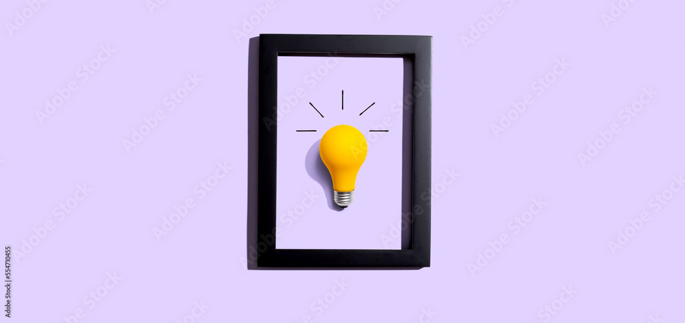 Yellow light bulb inside a frame - inspiration, creativity, energy, electricity themes