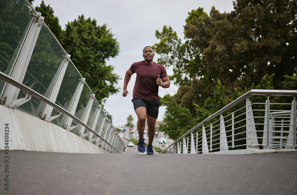 Black man running on bridge in city for fitness, exercise and healthy goals, sports wellness and mar