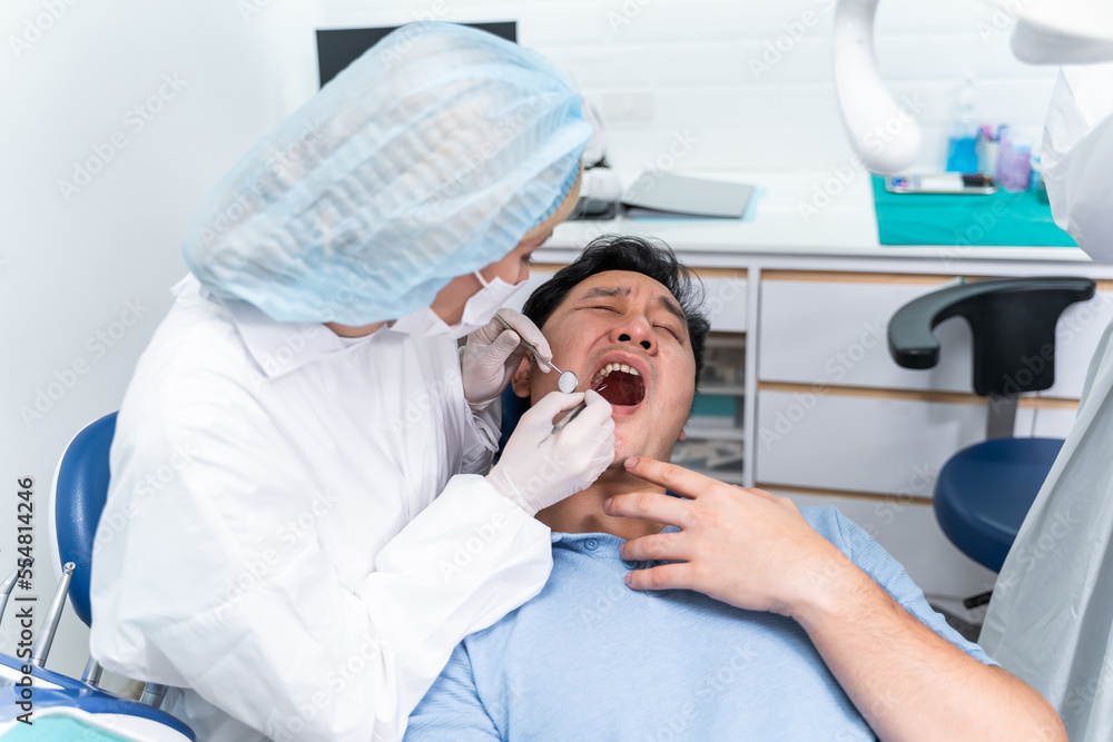 Caucasian dentist examine tooth for young man patient at dental clinic. 