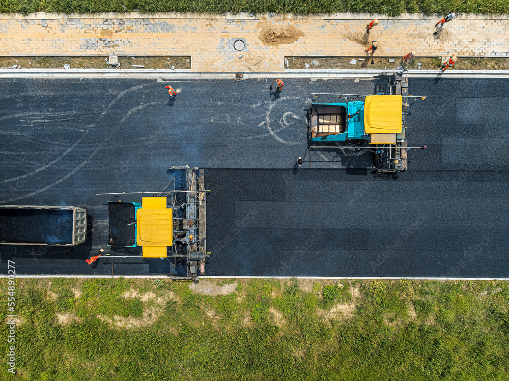 Aerial view of construction site is laying new asphalt pavement. road construction workers and road 