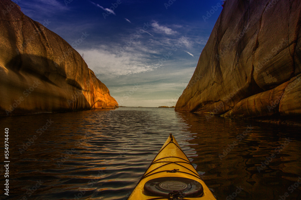 paddle in a kayak through a narrow channel and out towards the horizon