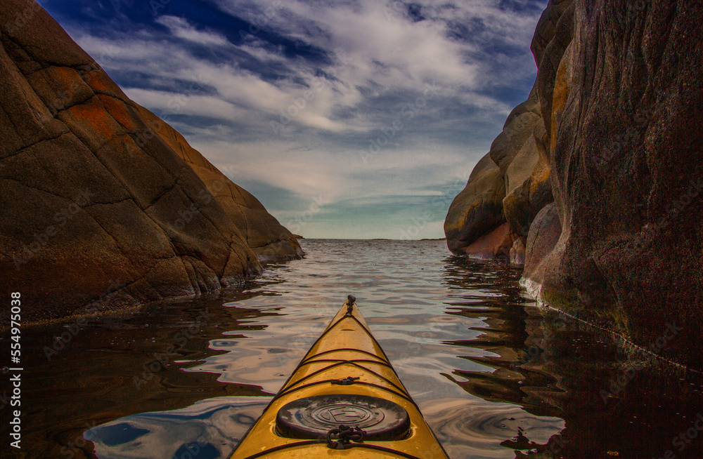 paddle in a kayak through a narrow channel and out towards the horizon