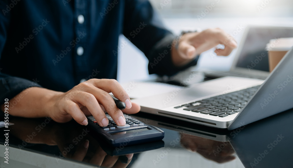 Close up of businesswoman or accountant hand typing laptop working to calculate on desk about cost a