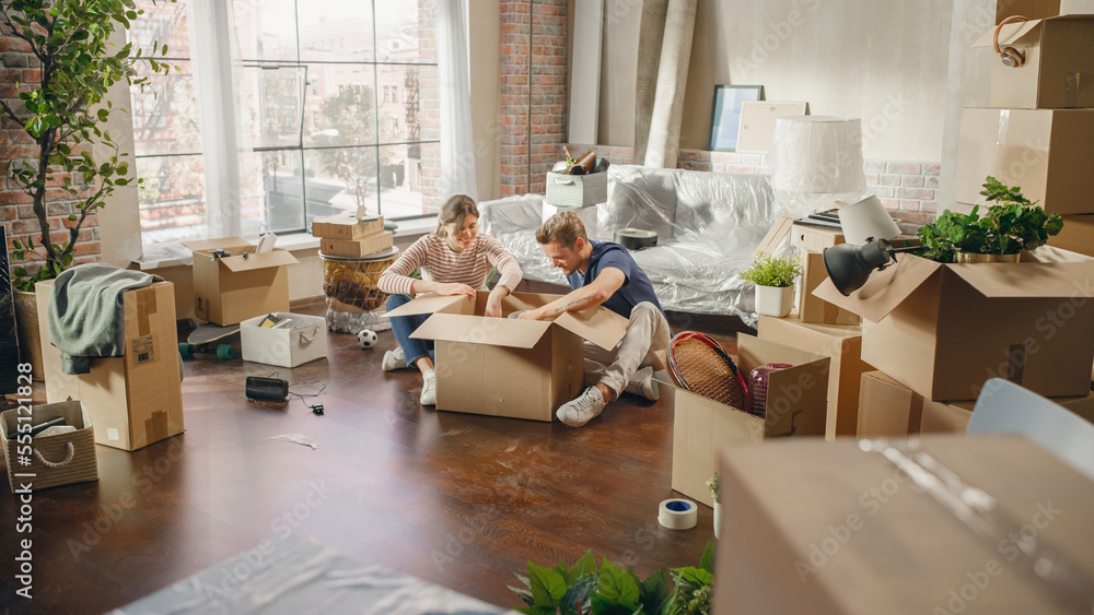 Happy Young Homeowners Moving In: Happy Couple Sitting on the Floor of the Newly Purchased Apartment