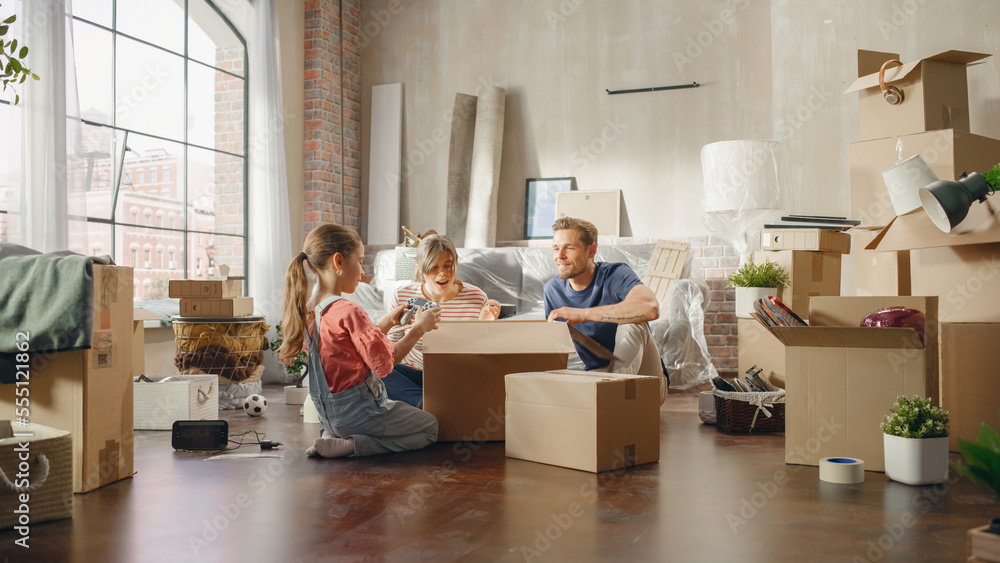 Happy Homeowners Moving In: Lovely Couple Sitting on the Floor of Cozy Apartment Unpacking Cardboard