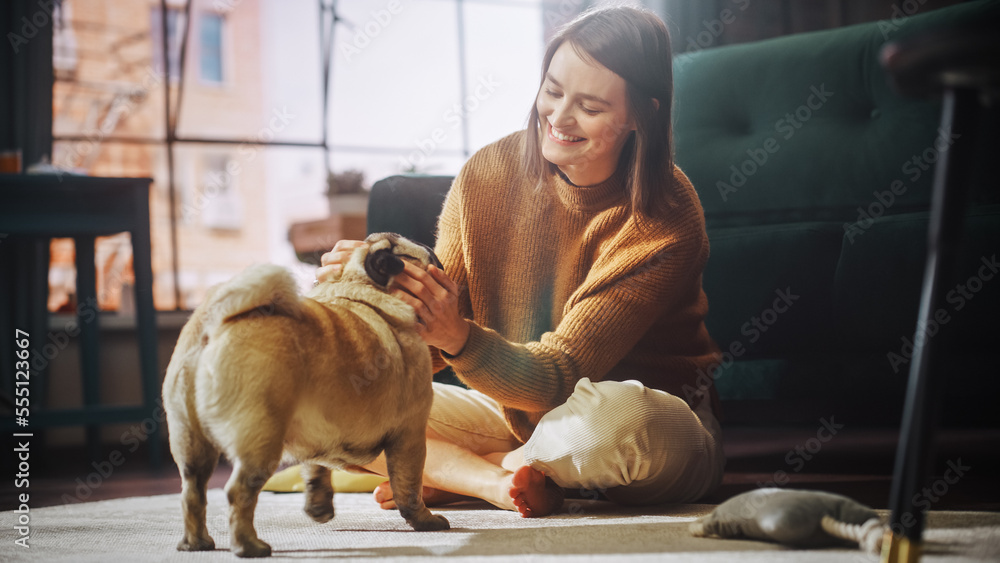 Beautiful Young Woman Cuddles Her Adorable Little Pug at Home. Girl Plays with Her Dog, Gorgeous Ped