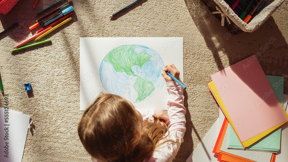 Top View: Little Girl Drawing Our Beautiful Planet Earth. Very Talented Child Having Fun at Home on 