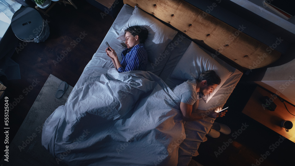 Top View Apartment Bedroom: Caucasian Young Couple Lying in Bed, Using Smartphones. Family of Two Us