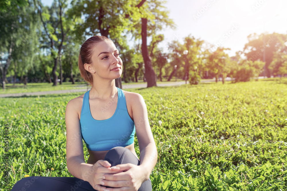 Beautiful smiling girl in activewear relax in park