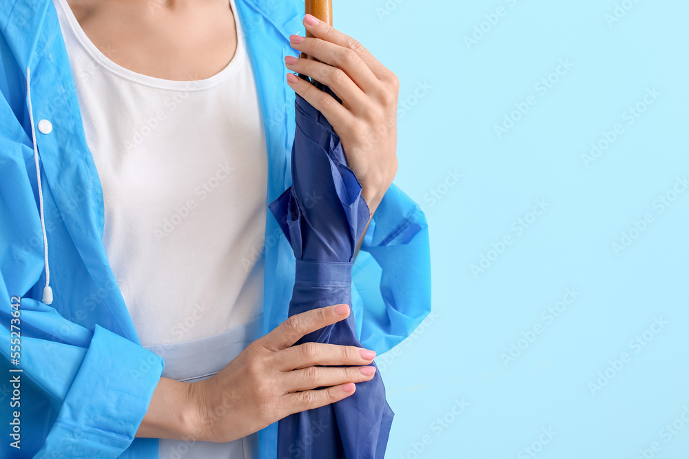 Young woman holding umbrella on color background, closeup