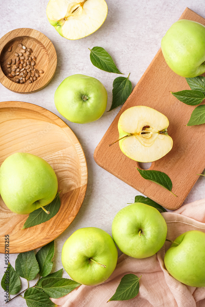 Fresh green apples and leaves on light background