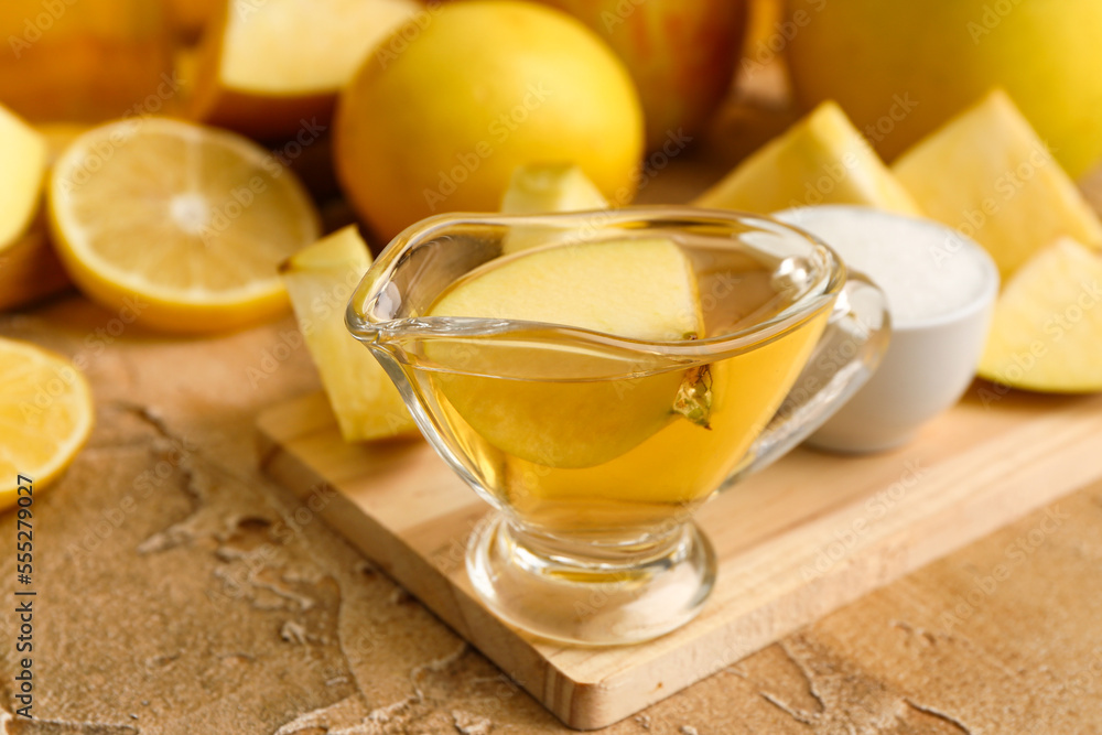 Gravy boat of apple cider vinegar on color table, closeup