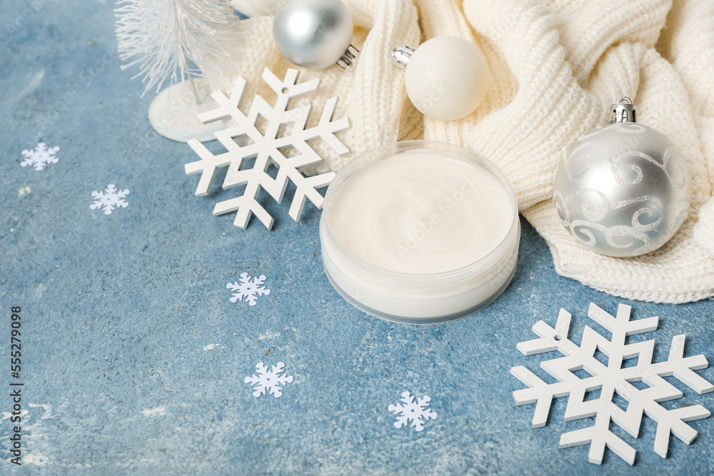 Composition with jar of cream, clothes and Christmas decorations on color background