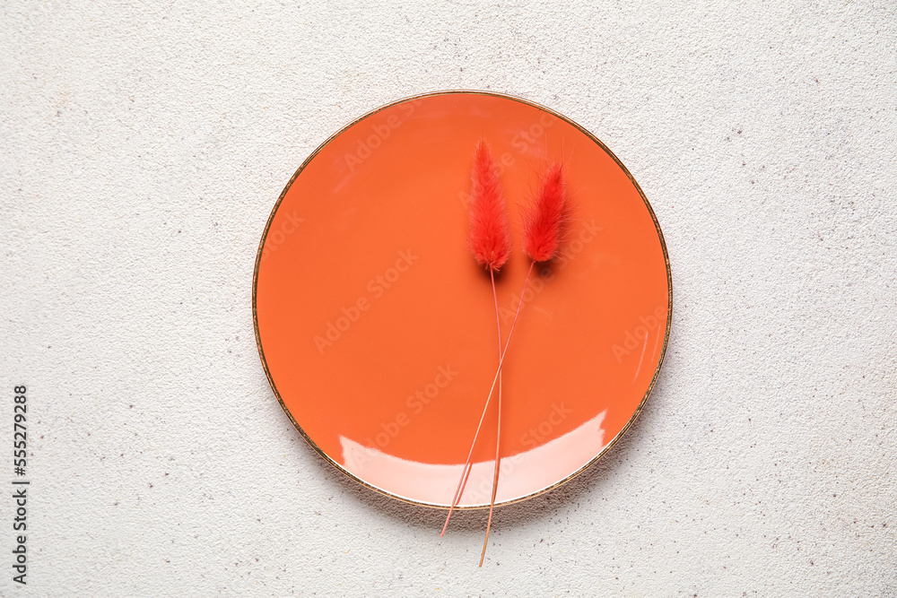 Orange plate with floral decor on grey background