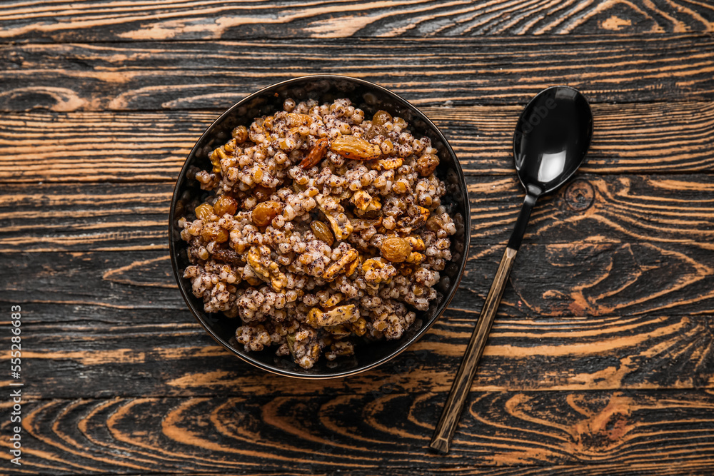 Bowl of Kutya and spoon on dark wooden background