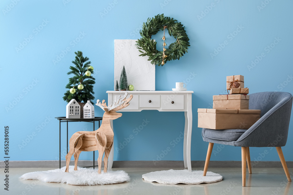 Interior of living room with Christmas wreath, fir trees and table