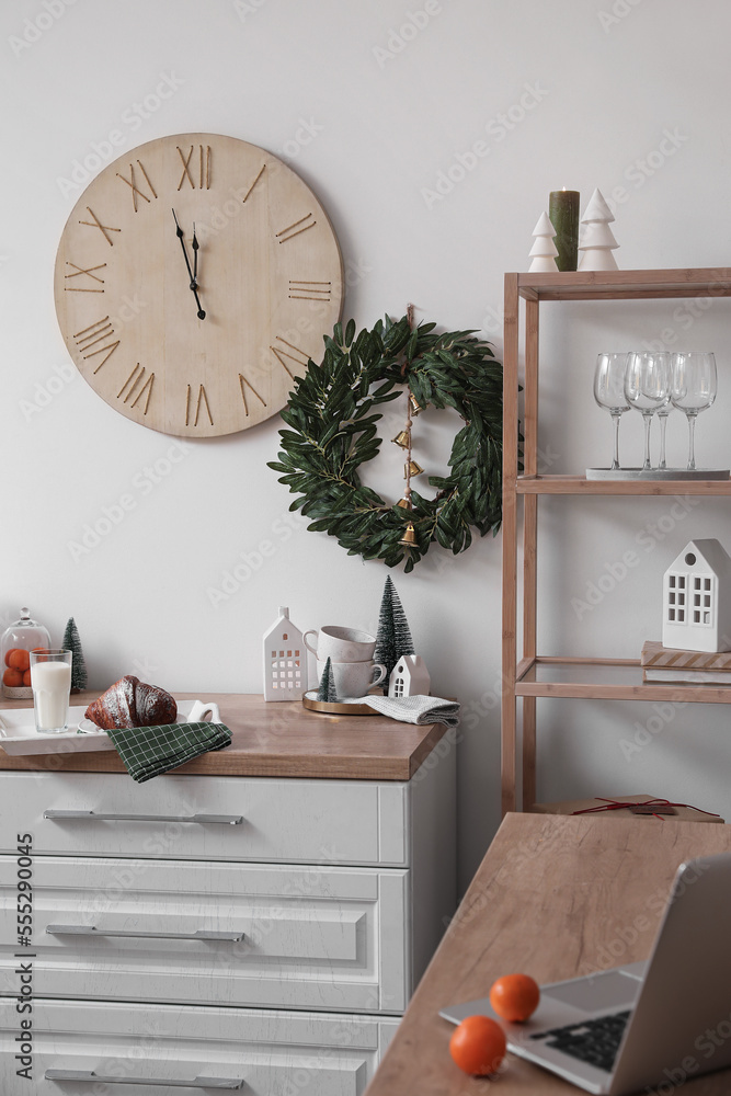 Interior of kitchen with Christmas wreath and big clock