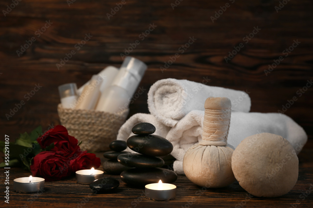 Beautiful spa composition for Valentines Day with stones, candles, towels, herbal bags and rose flo