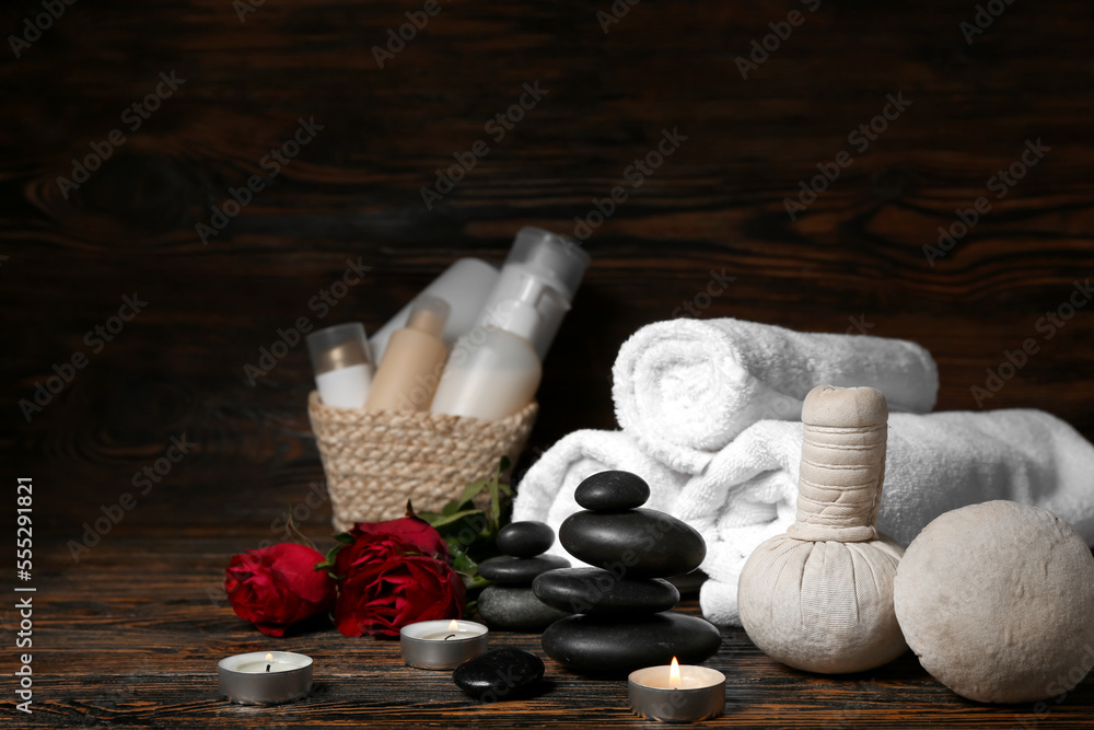 Beautiful spa composition for Valentines Day with stones, candles, towels, herbal bags and rose flo