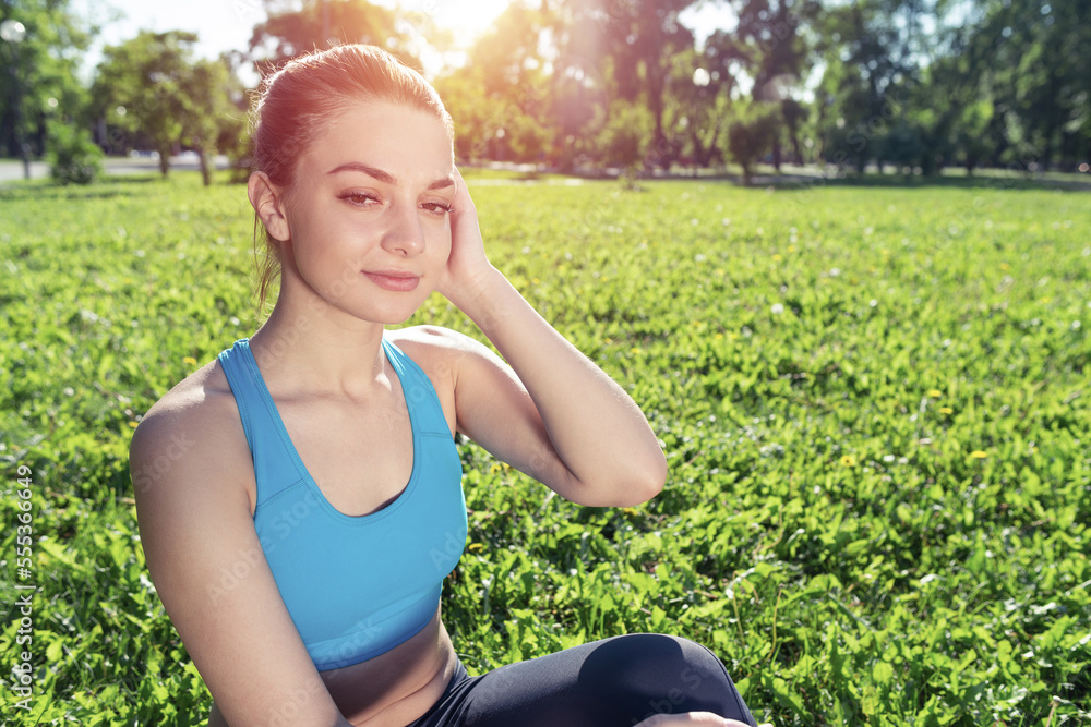 Beautiful smiling girl in sportswear relax in park