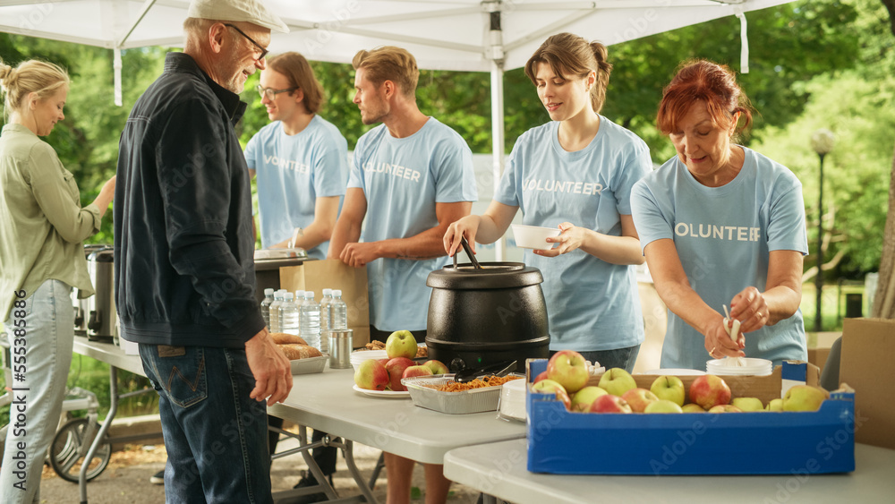 Team of Young Volunteers Helping in a Local Community Food Bank, Handing Out Free Food to Low-Income