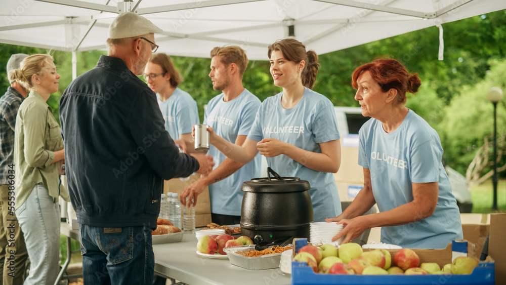 Happy Group of Young Adult Volunteers Serving Free Food for Poor People in Need. Charity Workers Hel