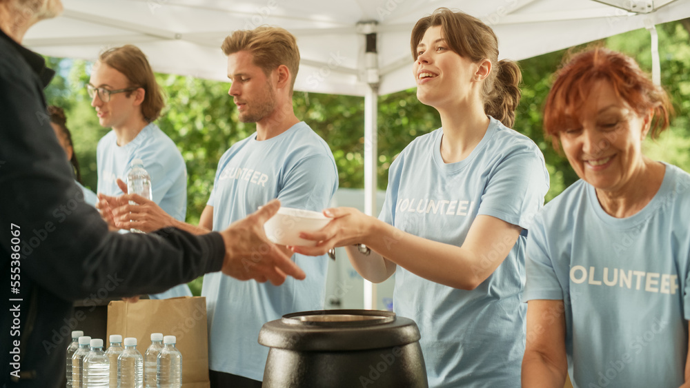 The Concept of Giving: Homeless People Reach Out To Free Volunteer Meals from Multiethnic Team of Vo