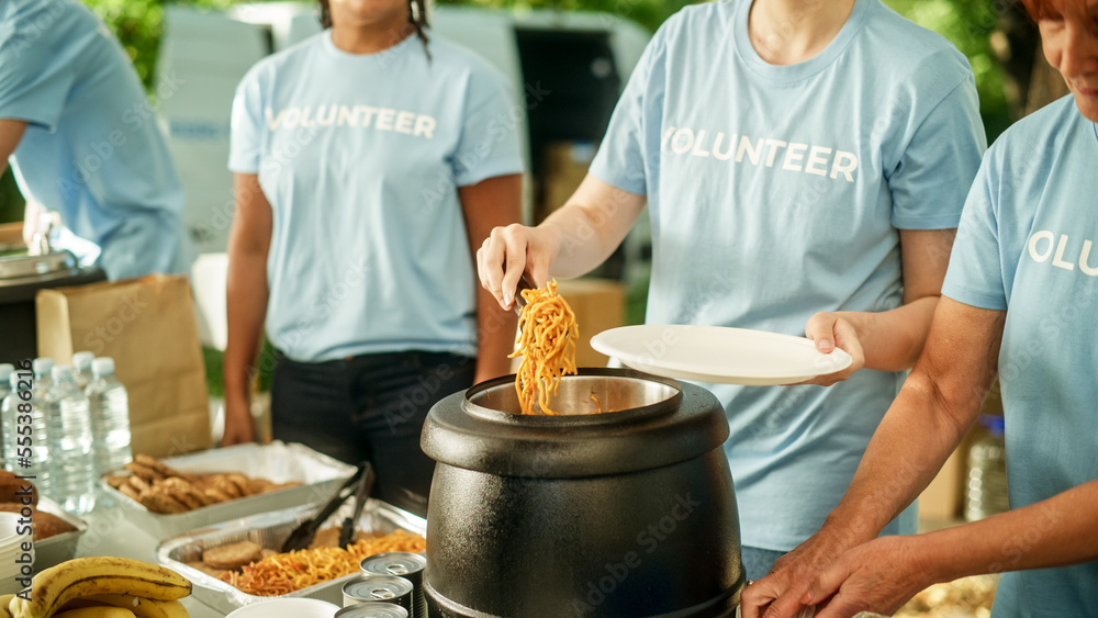 Close Up of a Team of Volunteers Helping in a Local Community Food Bank, Handing Out Free Food to Lo