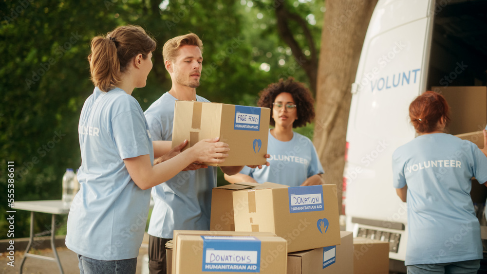 Happy Group of Volunteers Working on Delivering Humanitarian Aid and Donations, Loading Boxes into a