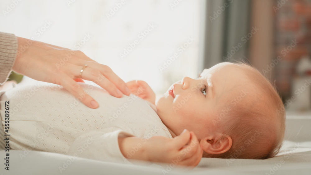 Close Up of a Mother Playing with a Cute Newborn Baby that is Lying on the Back in Child Crib in Coz