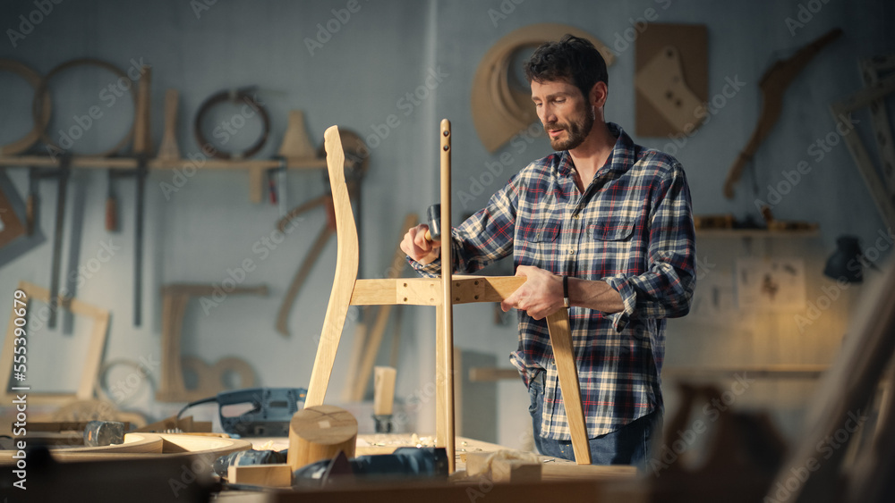 Young Woodworker Checking the Layout Manual of a Stylish Handmade Wooden Chair. Talented Furniture D