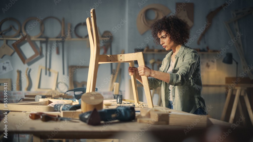 Portrait of a Young Beautiful Carpenter Checking a Blueprint and Starting to Assemble a Wooden Chair