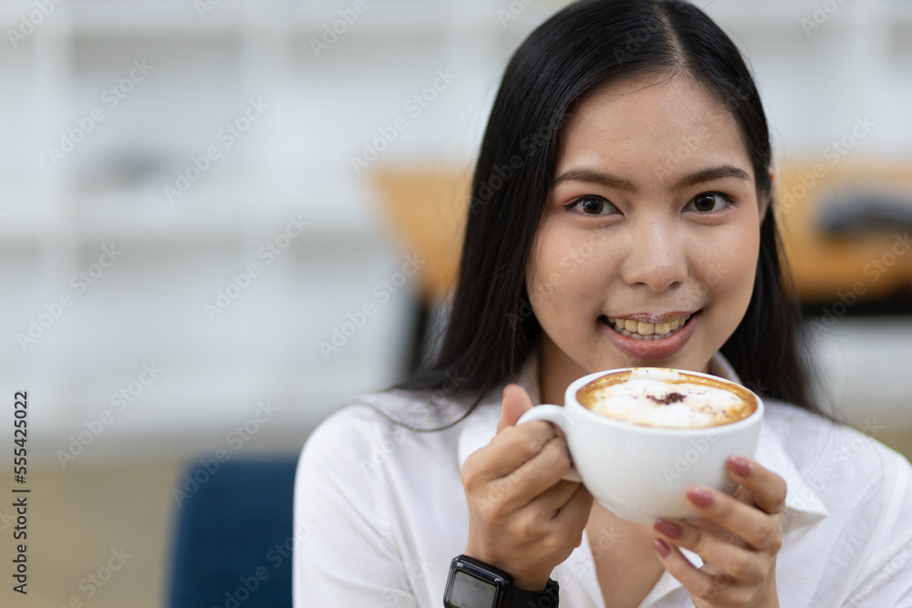 快乐的亚洲女人早上喝咖啡。