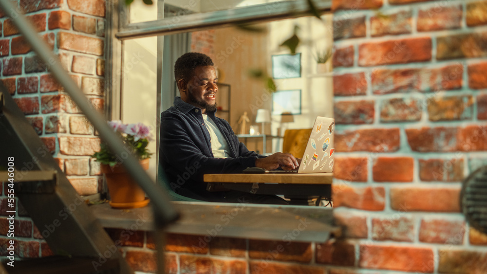 Young African Student Using Laptop at Home. Attending Online Class During the Day. Handsome Man Sitt