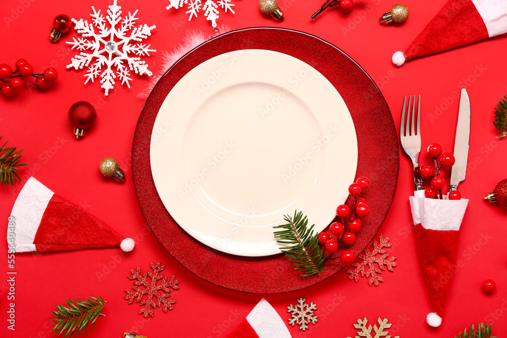 Beautiful table setting with Christmas decorations on red background