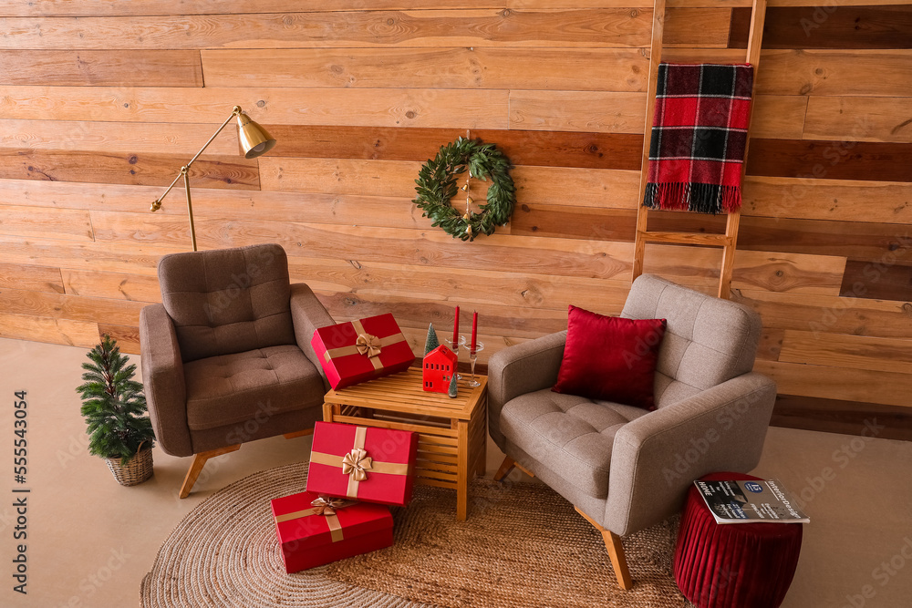 Interior of living room with Christmas wreath, armchairs and presents