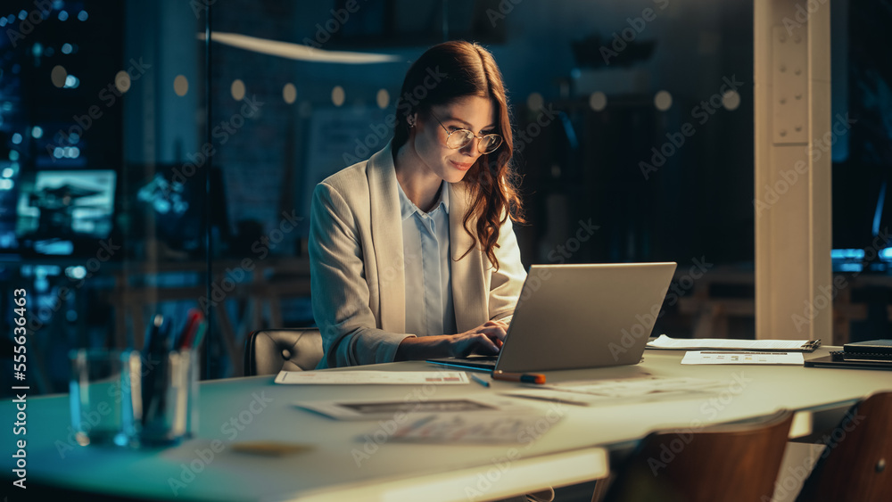 Stylish Female Working on Laptop Computer in a Company Office in the Evening. Young Manager Browsing