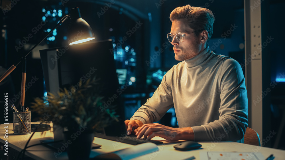 Portrait of a Stylish Male Working on Desktop Computer in a Company Office in the Evening. Young Man