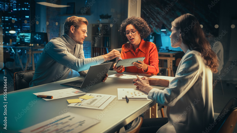 Diverse Team of Young Managers Discussing Work at a Meeting in Office at Night. Successful Business 