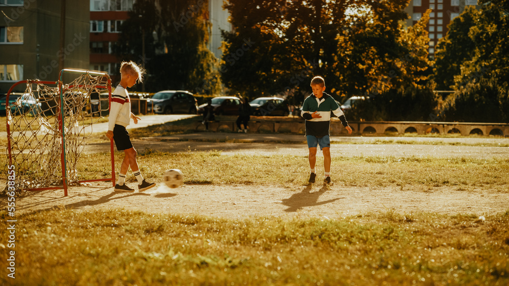 Neighborhood Kids Playing Soccer in the Backyard. Young Football Player Scoring a Goal. Two Boys Kic