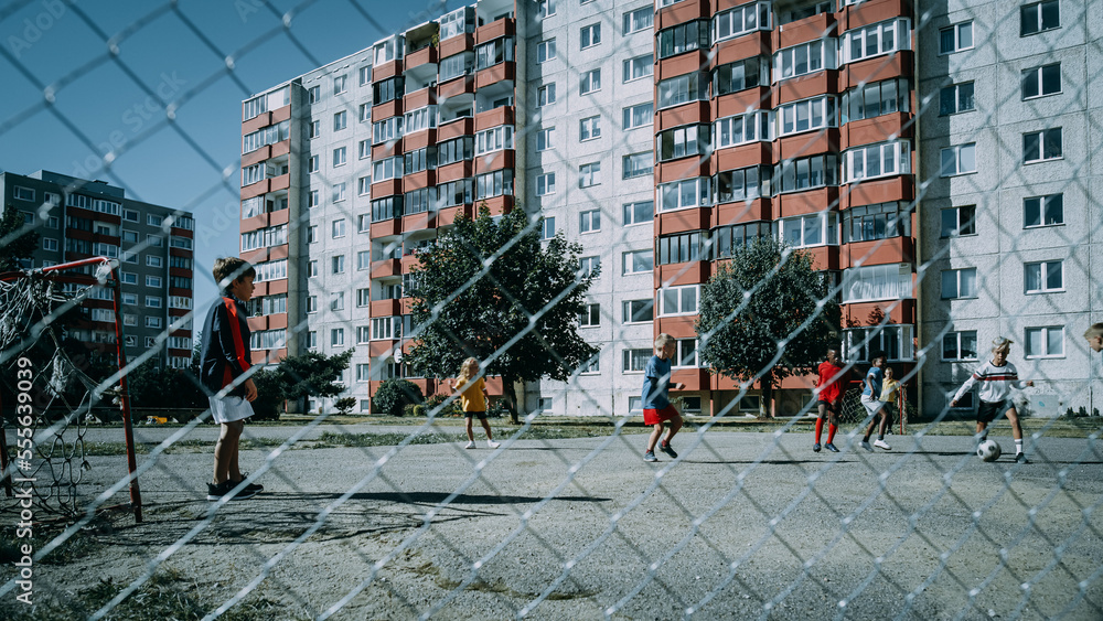 Neighborhood Kids Playing Soccer Outside in Urban Backyard. Young Football Player Making a Penalty K