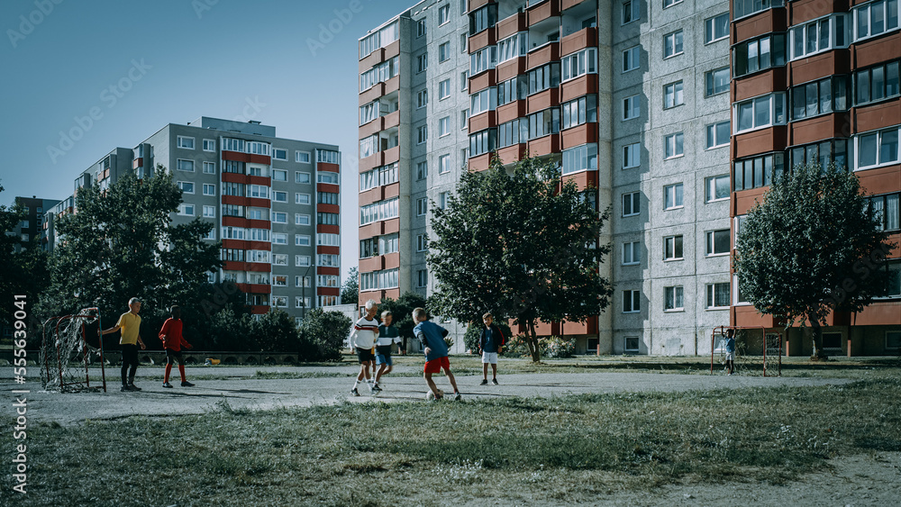 Neighborhood Kids Playing Soccer in Eastern European Backyard. Young Football Players Dribbling, Sco